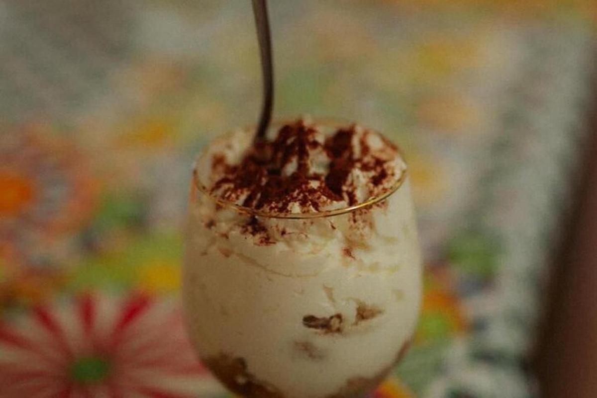 a dessert with a spoon in a glass with a drink