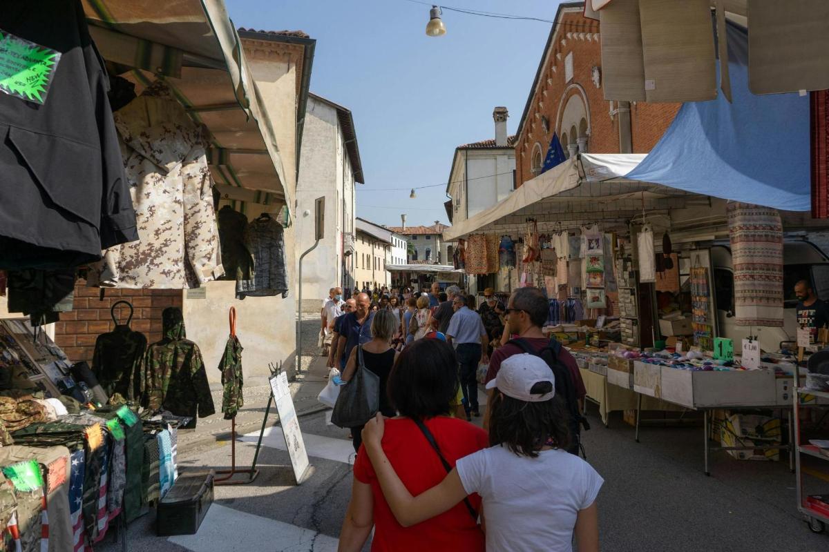 un grup de oameni care se plimbă printr-o piață