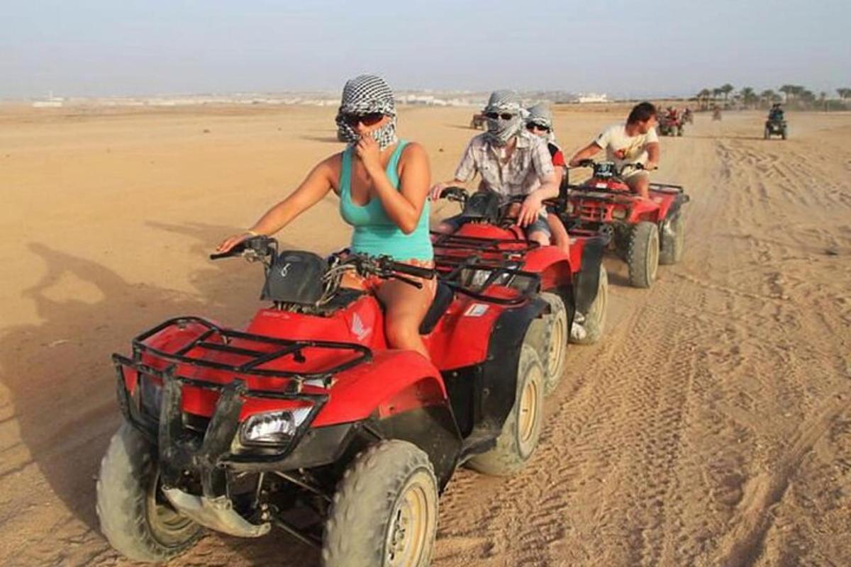un gruppo di persone in sella a quad nel deserto