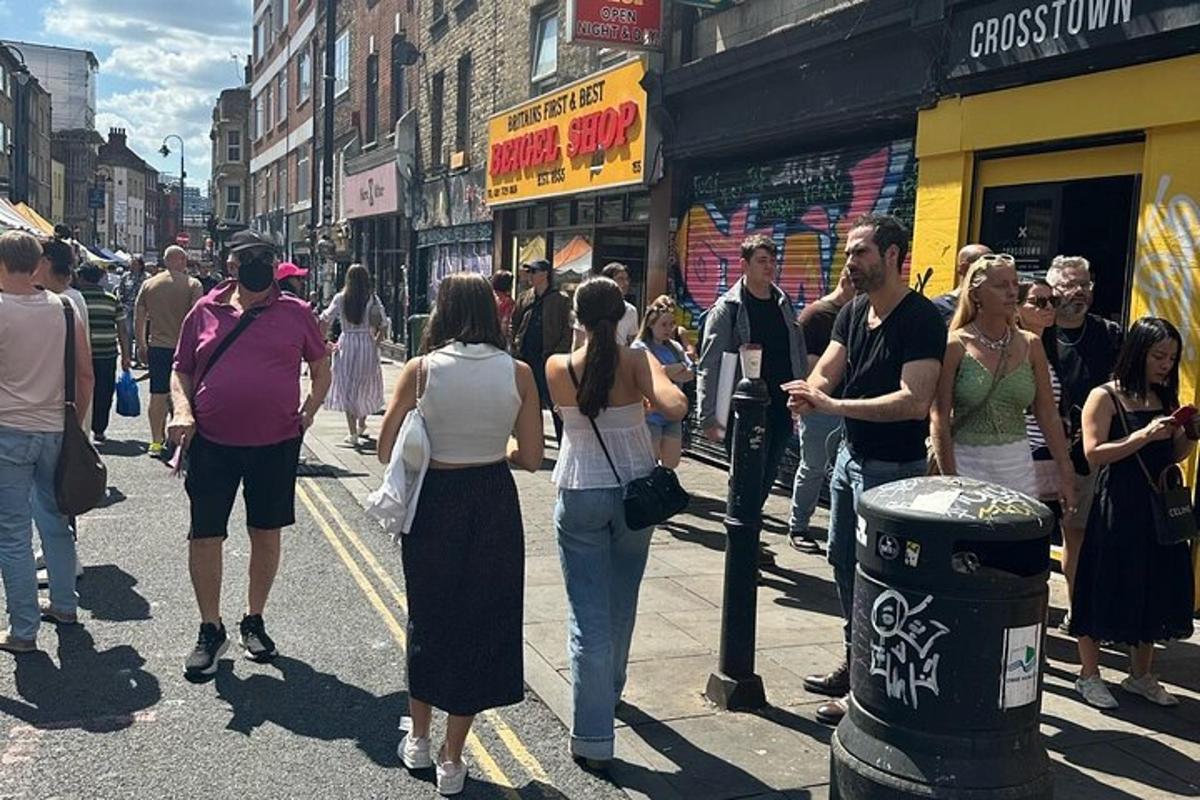 un gruppo di persone che camminano lungo una trafficata strada cittadina