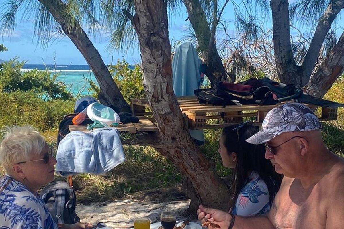 un gruppo di persone sedute a un tavolo da picnic sulla spiaggia