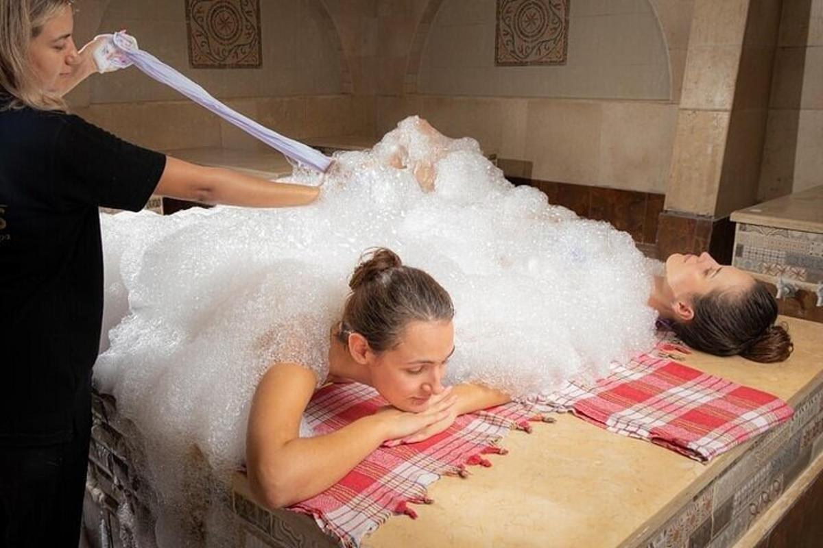 một người phụ nữ đang tắm cho một đứa trẻ trong bồn nước nóng