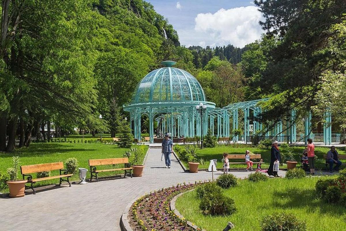 egy csoport ember sétál egy pavilonnal körülvett parkban