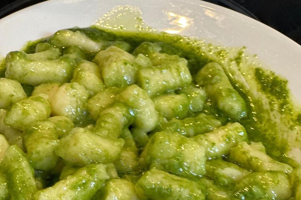 Un plato blanco de comida con comida verde encima.