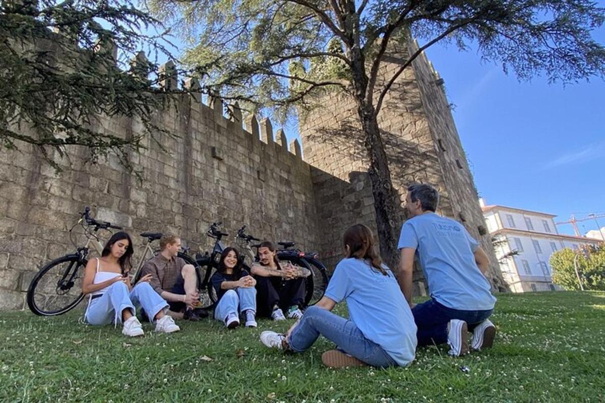um grupo de pessoas sentadas na grama perto de uma parede