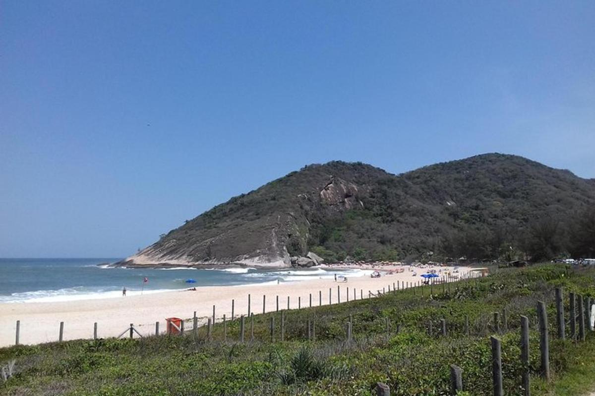 egy strand emberekkel a vízben és egy hegy