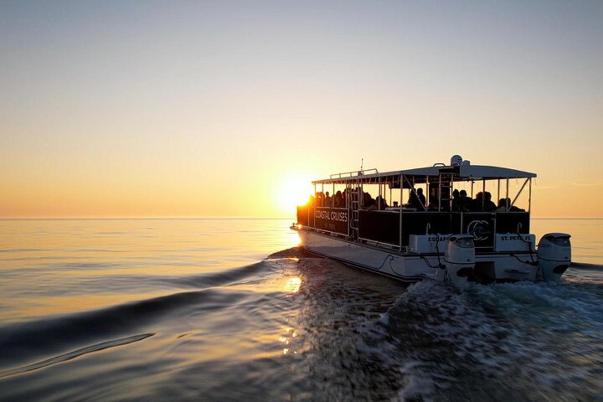 una barca piena di persone in acqua al tramonto