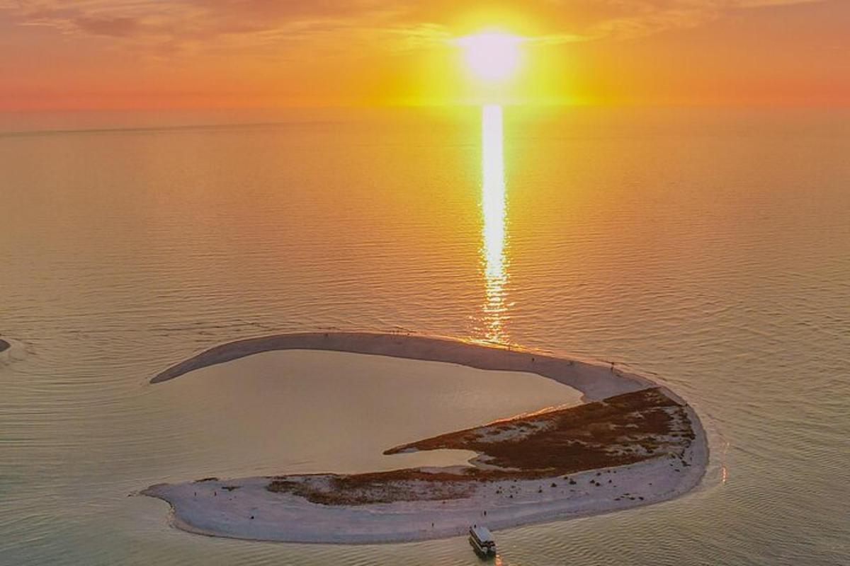 un'isola in mezzo all'acqua con un tramonto