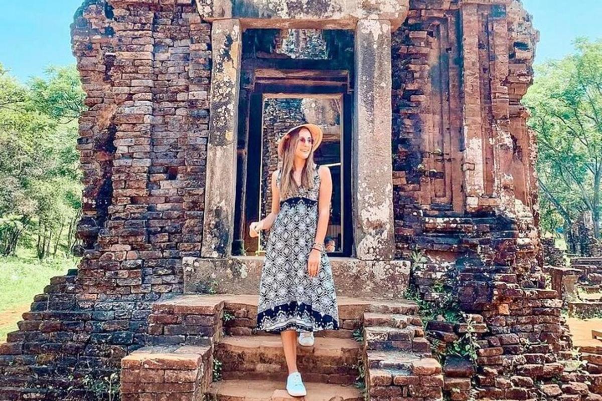 một người phụ nữ mặc váy đứng trên một số tàn tích