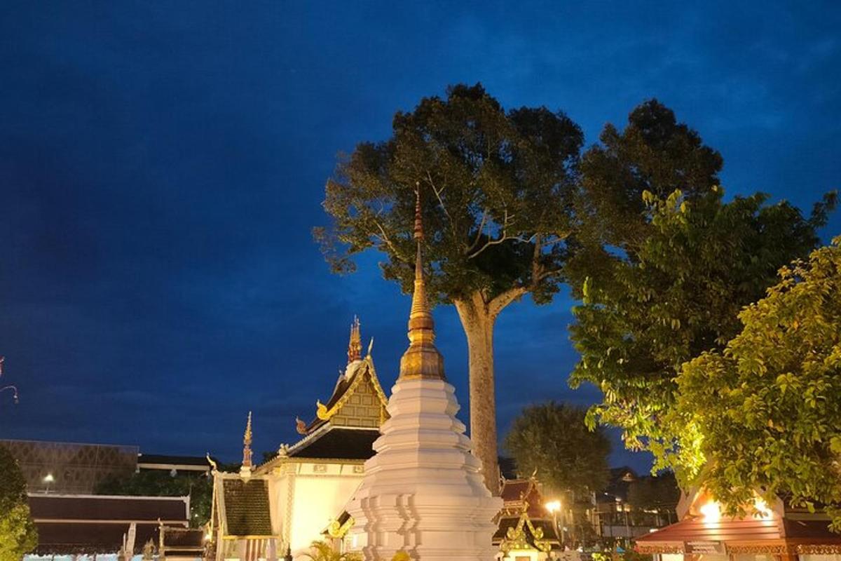 a white pagoda with a tree in front of a building