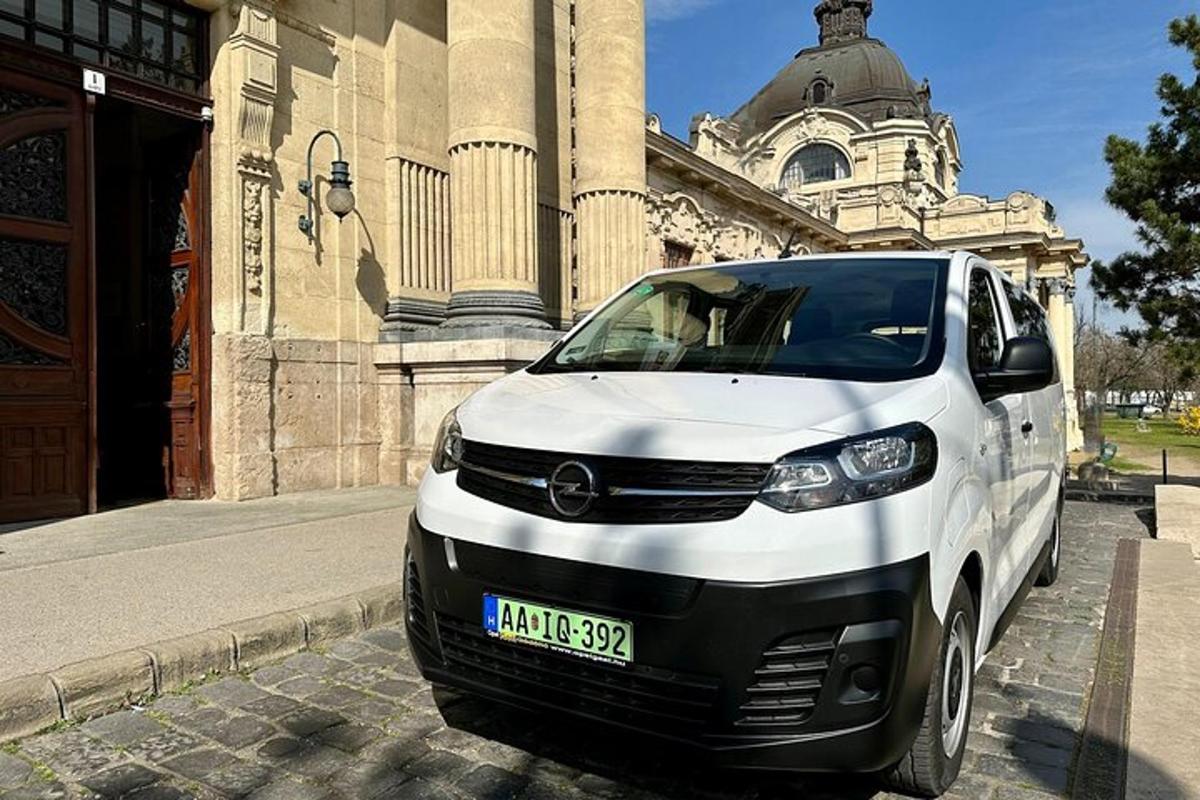 sebuah kereta putih berhenti di hadapan sebuah bangunan