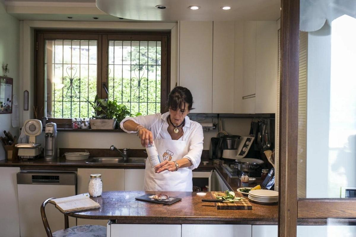 una donna in piedi in cucina che prepara il cibo