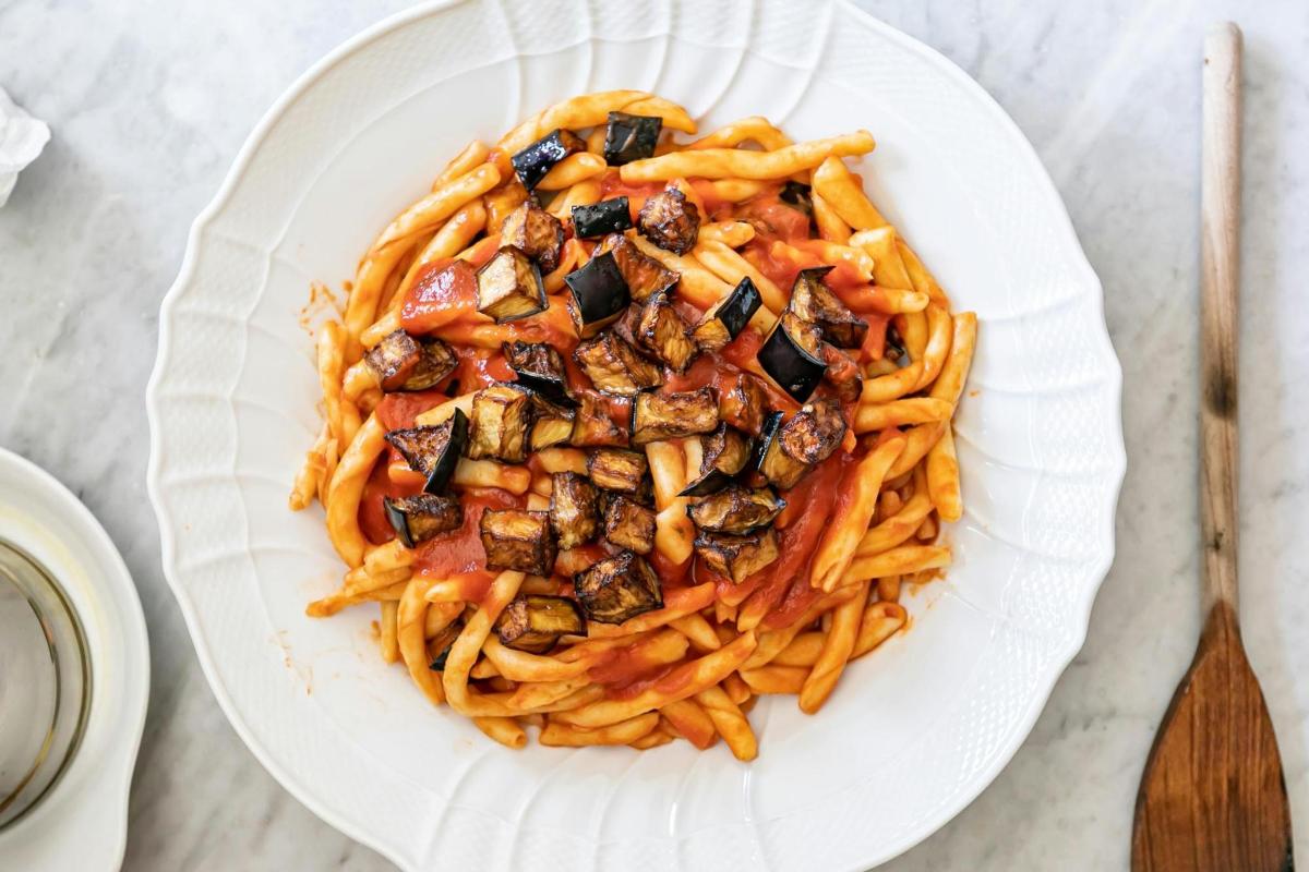 un piatto di pasta con funghi e pomodori