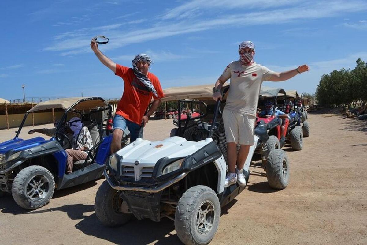 due uomini in piedi accanto a un gruppo di quad