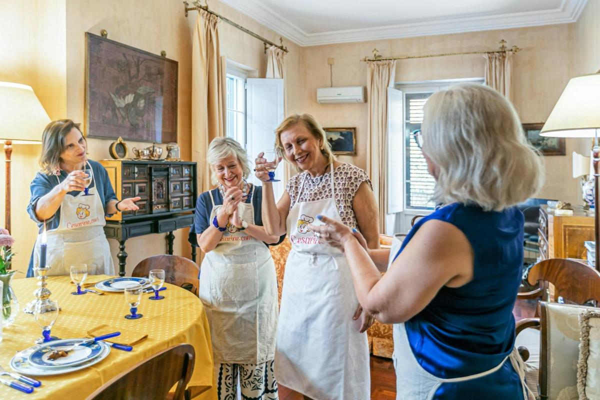 hópur kvenna stendur við borð og drekkur vín