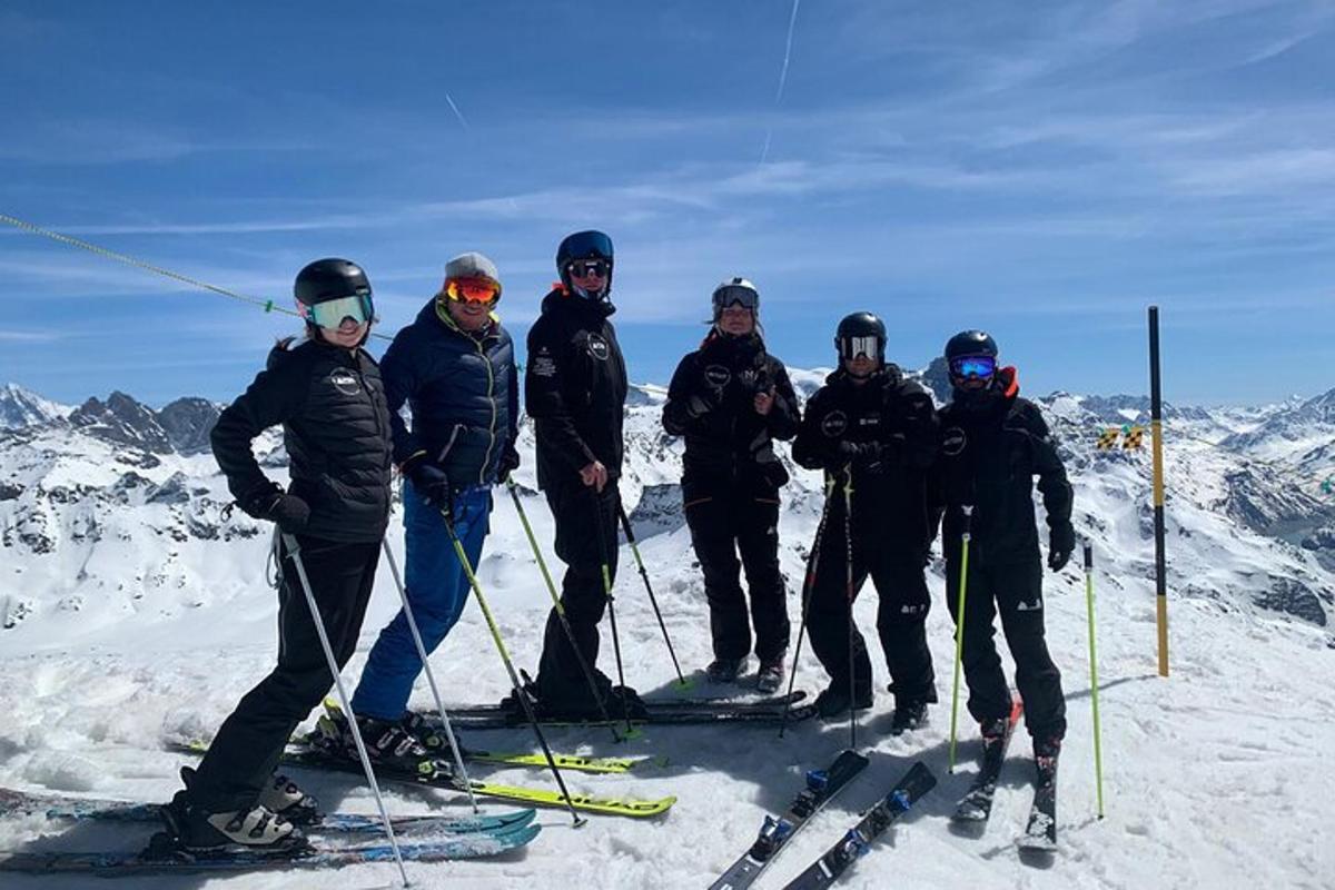 um grupo de pessoas em pé no topo de uma montanha coberta de neve