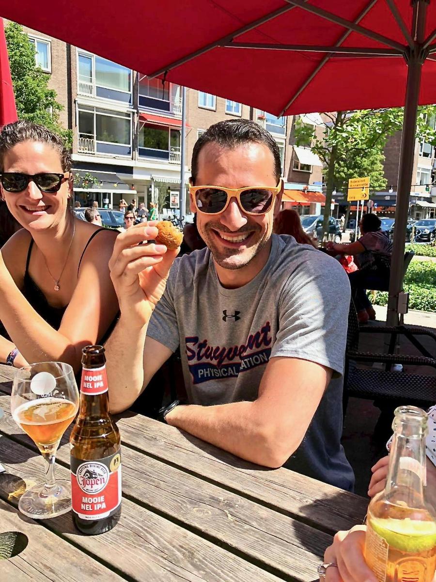 muž a žena sedící u stolu a jedoucí sendvič