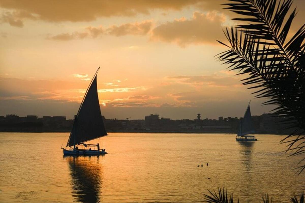 dua perahu layar di atas air saat matahari terbenam