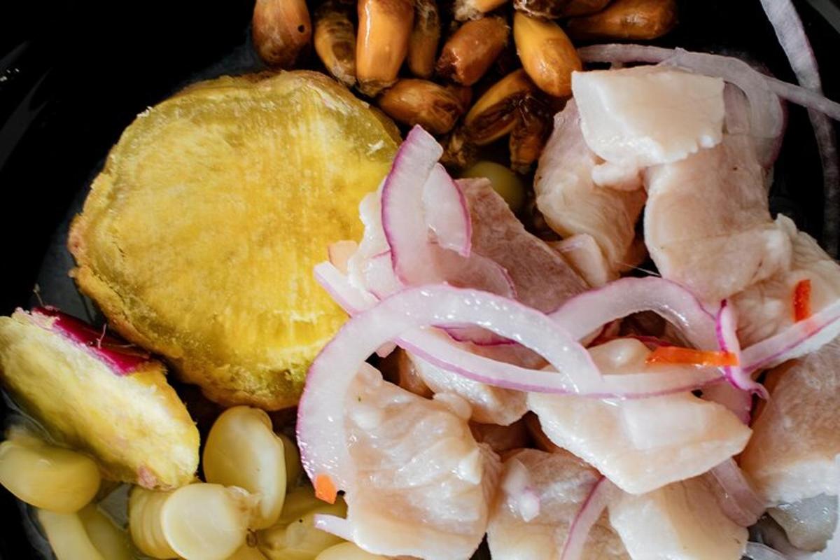 Un plato de comida con carne, cebollas y frijoles.