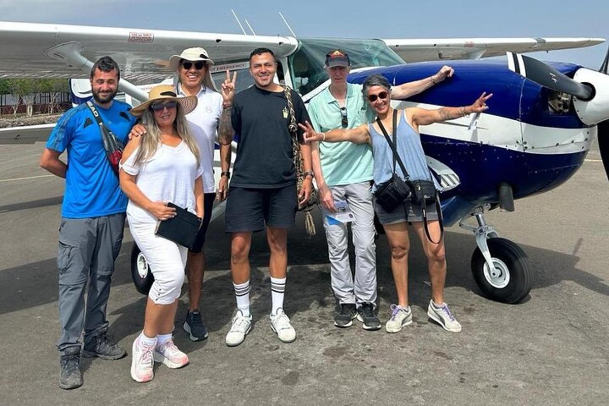 a group of people standing in front of a small plane