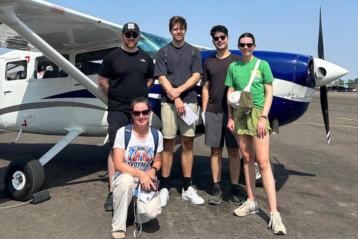 a group of people standing in front of a plane