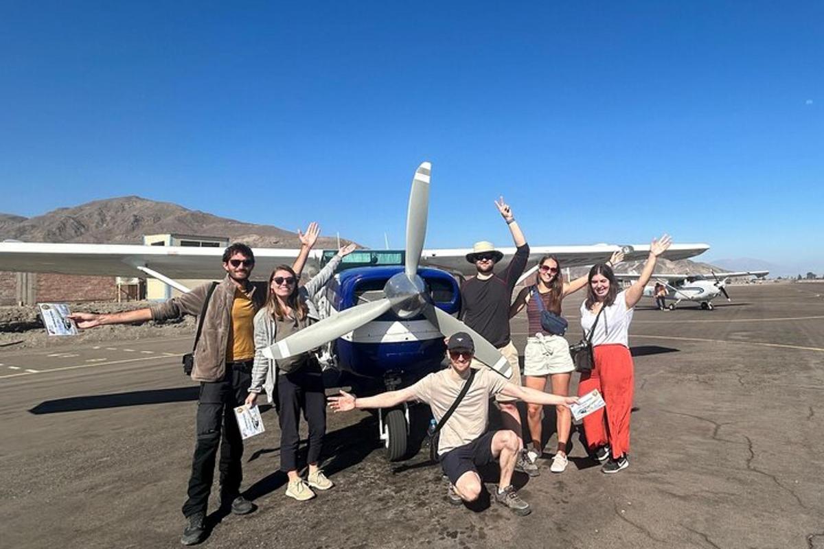 a group of people posing in front of an airplane