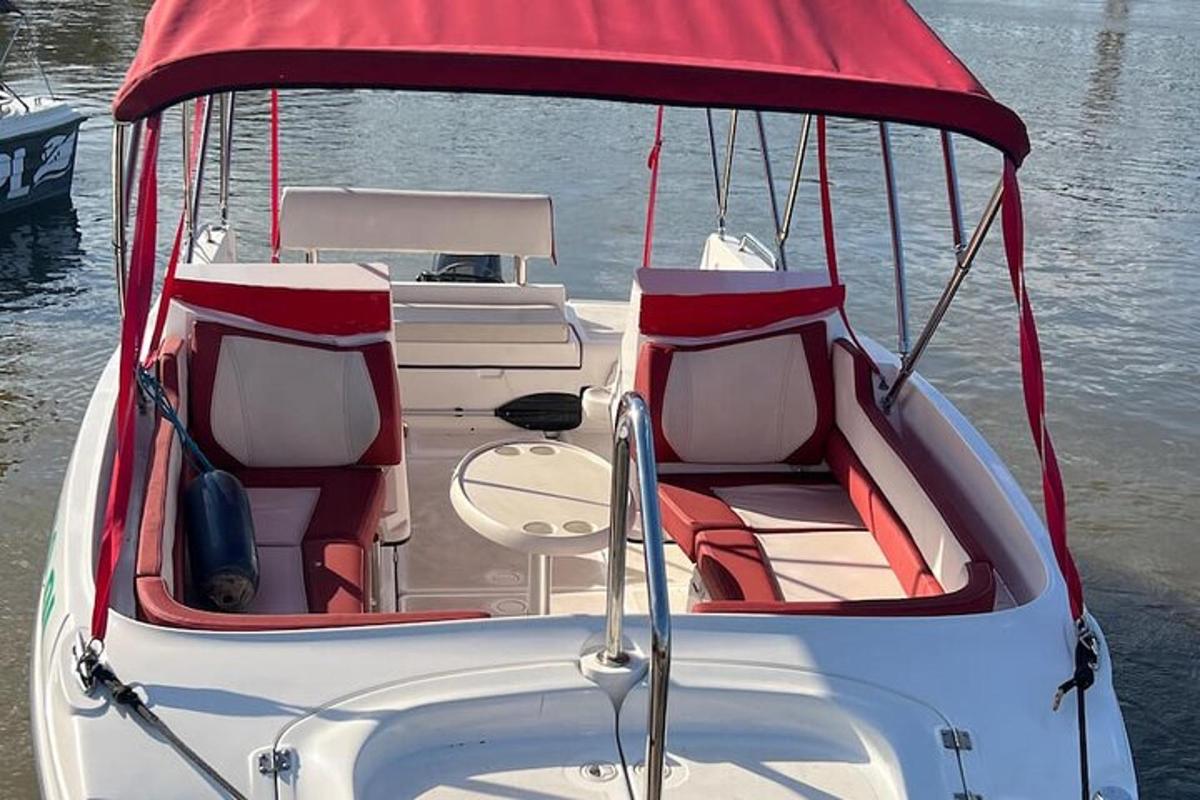 a white boat with a red roof on the water