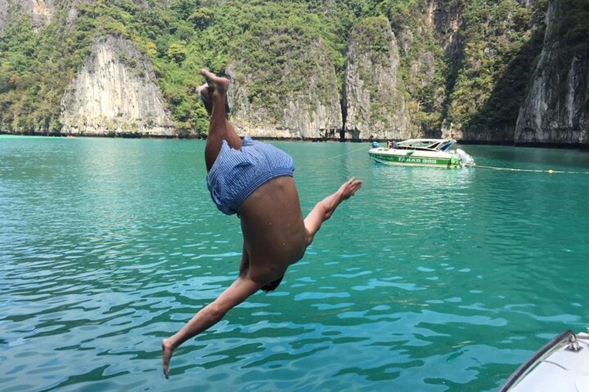 isang taong tumatalon mula sa isang bangka patungo sa isang anyong tubig