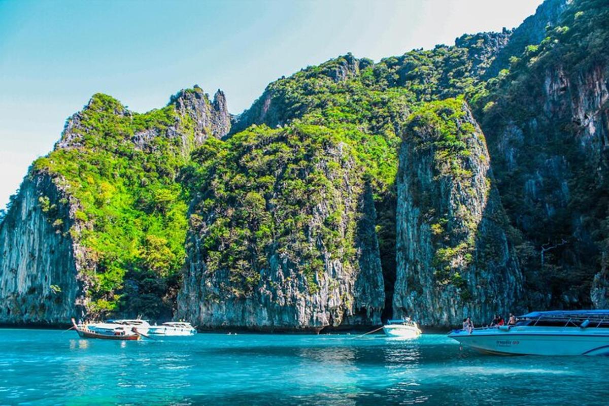 a group of boats in the water in front of a mountain