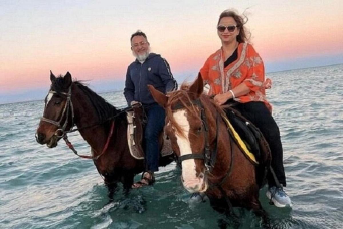 due persone a cavallo in acqua