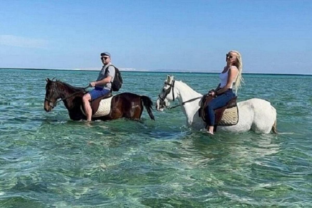 un uomo e una donna a cavallo nell'oceano