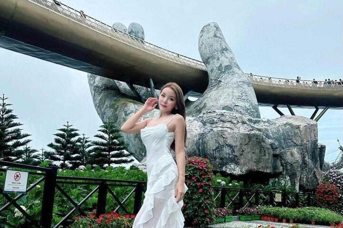 una donna in abito bianco in piedi davanti a un ponte