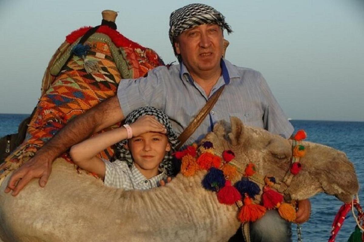 un home i un nen asseguts sobre un animal gran