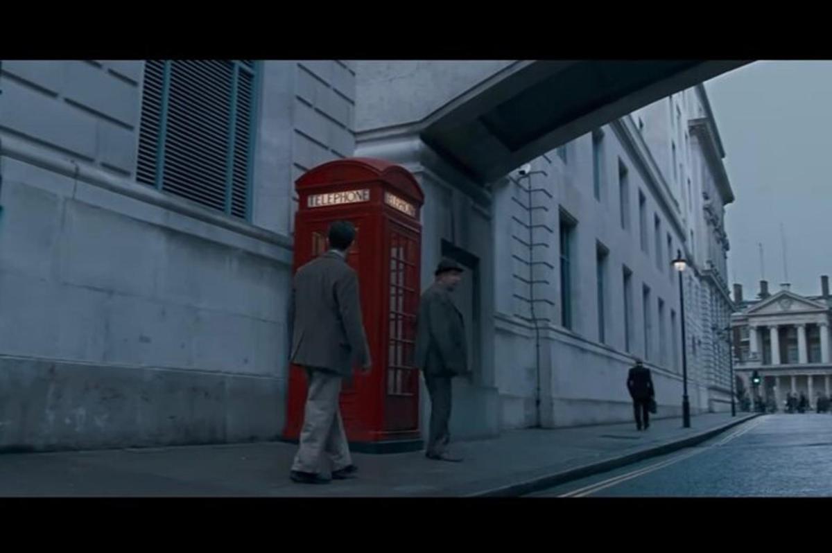 dva muži stojící vedle červené telefonní budky