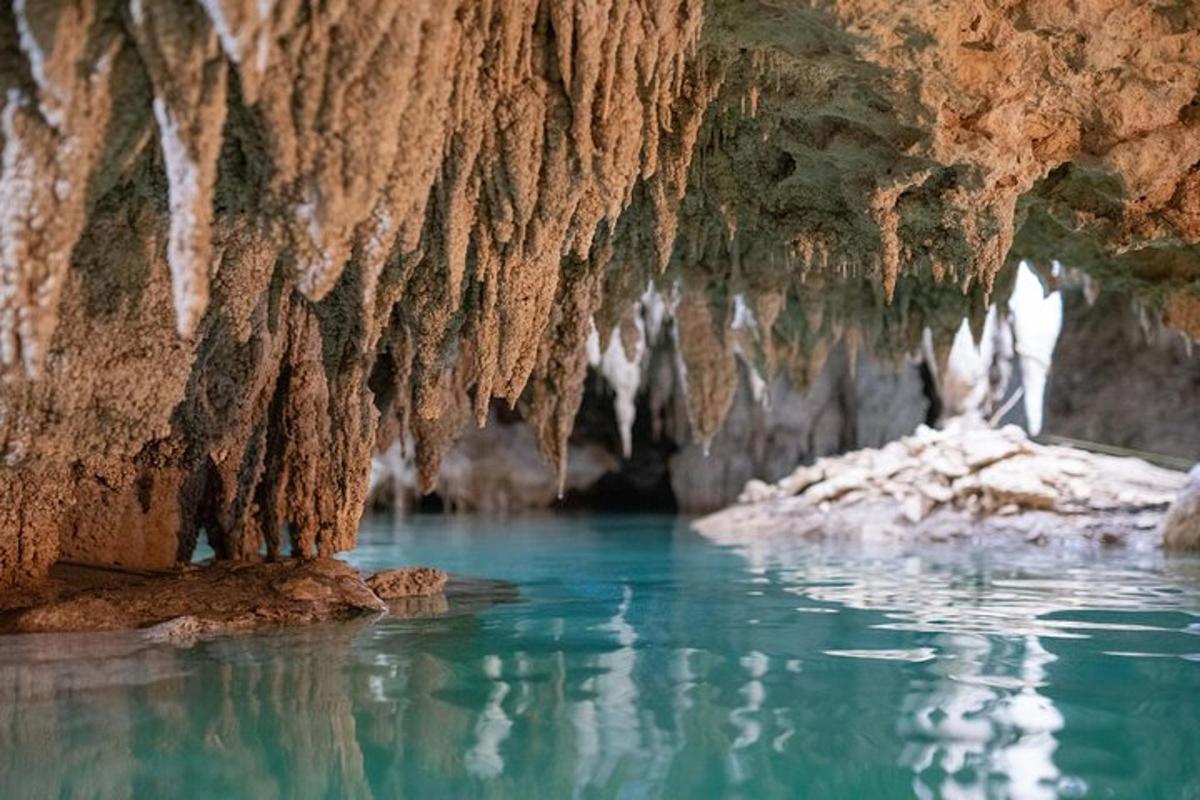 une grotte avec de l'eau bleue et des glaçons dedans