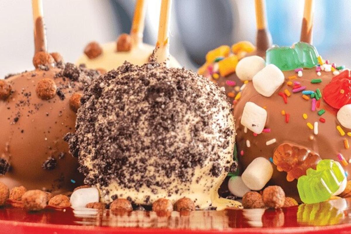 a chocolate donut with sprinkles on a red plate