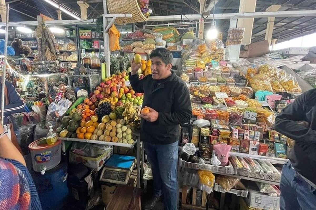 Un hombre parado en un mercado sosteniendo un ramo de fruta.
