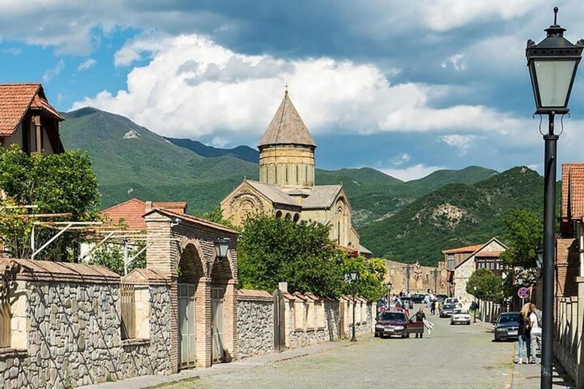 una calle de un pueblo con una iglesia y una torre