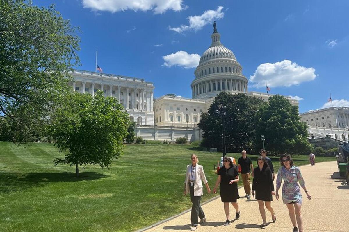 egy csoport ember sétál az amerikai Capitolium épülete előtt