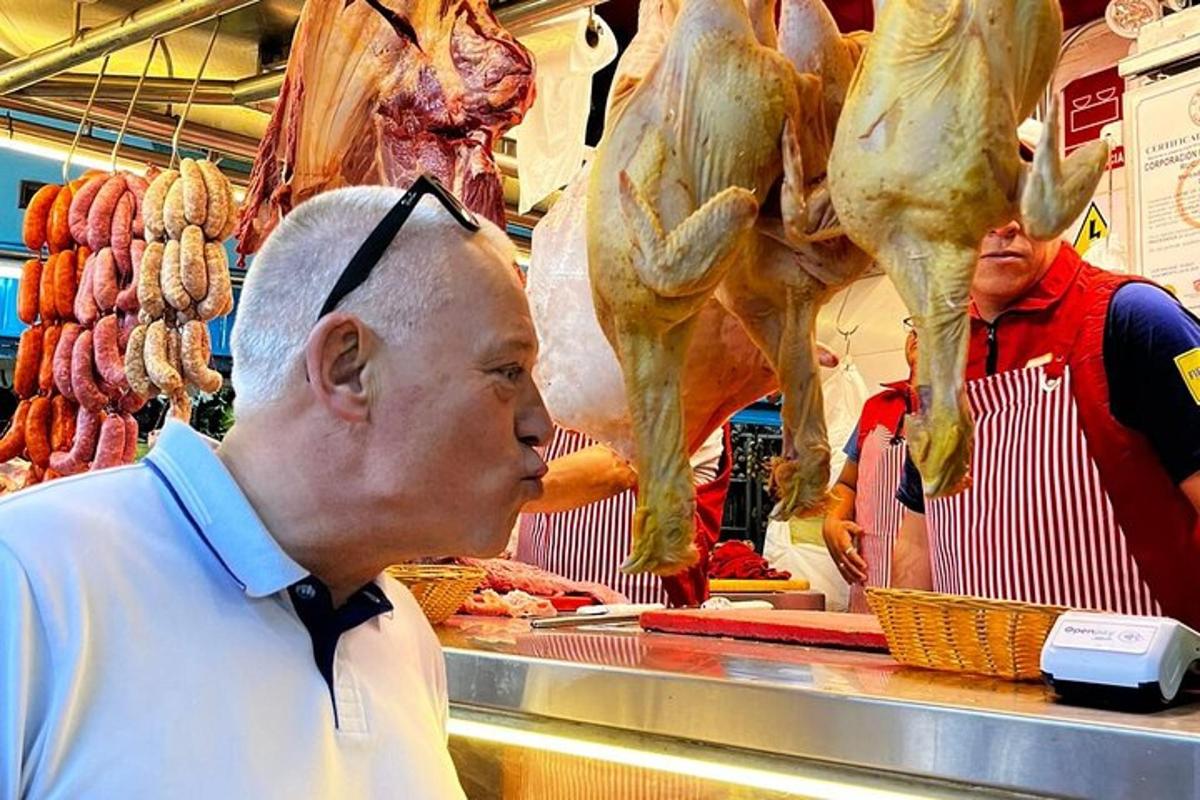 Ένας άντρας που στέκεται σε ένα κατάστημα κοιτάζοντας κρέας