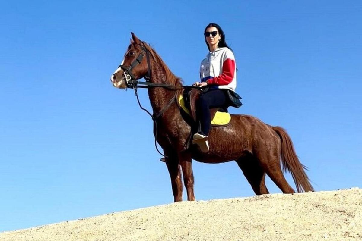 una donna a cavallo in cima a una collina
