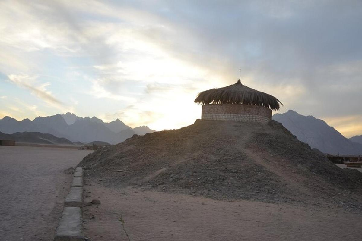 un edificio in cima a una collina con le montagne sullo sfondo