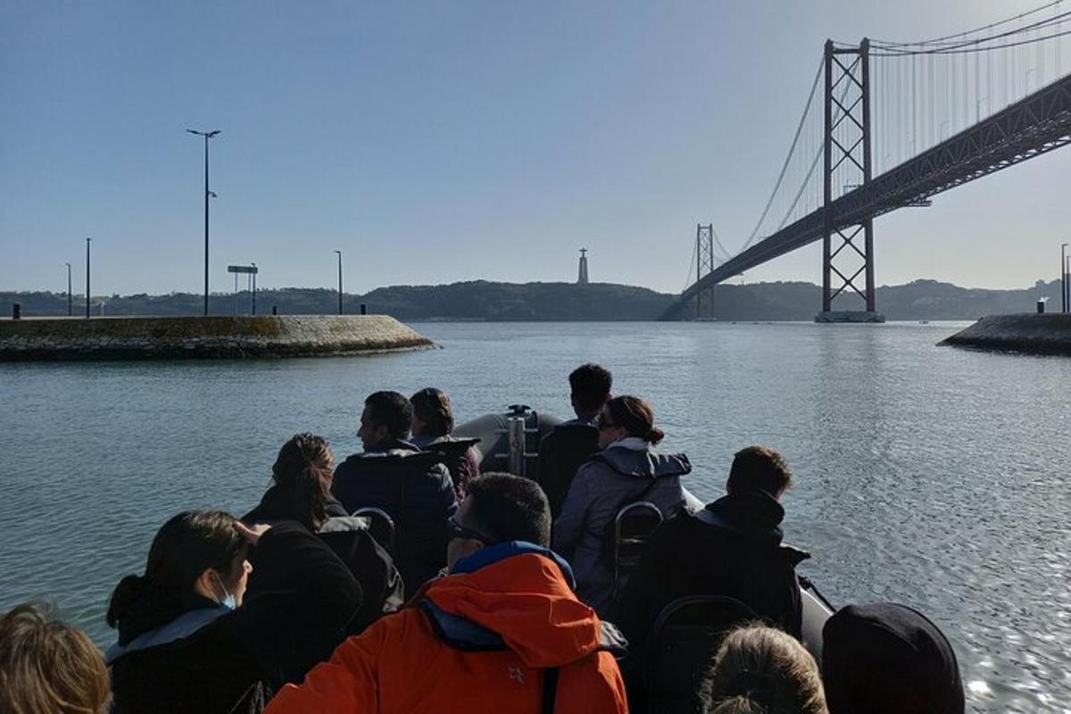 Un grupo de personas en un bote en el agua cerca de un puente.