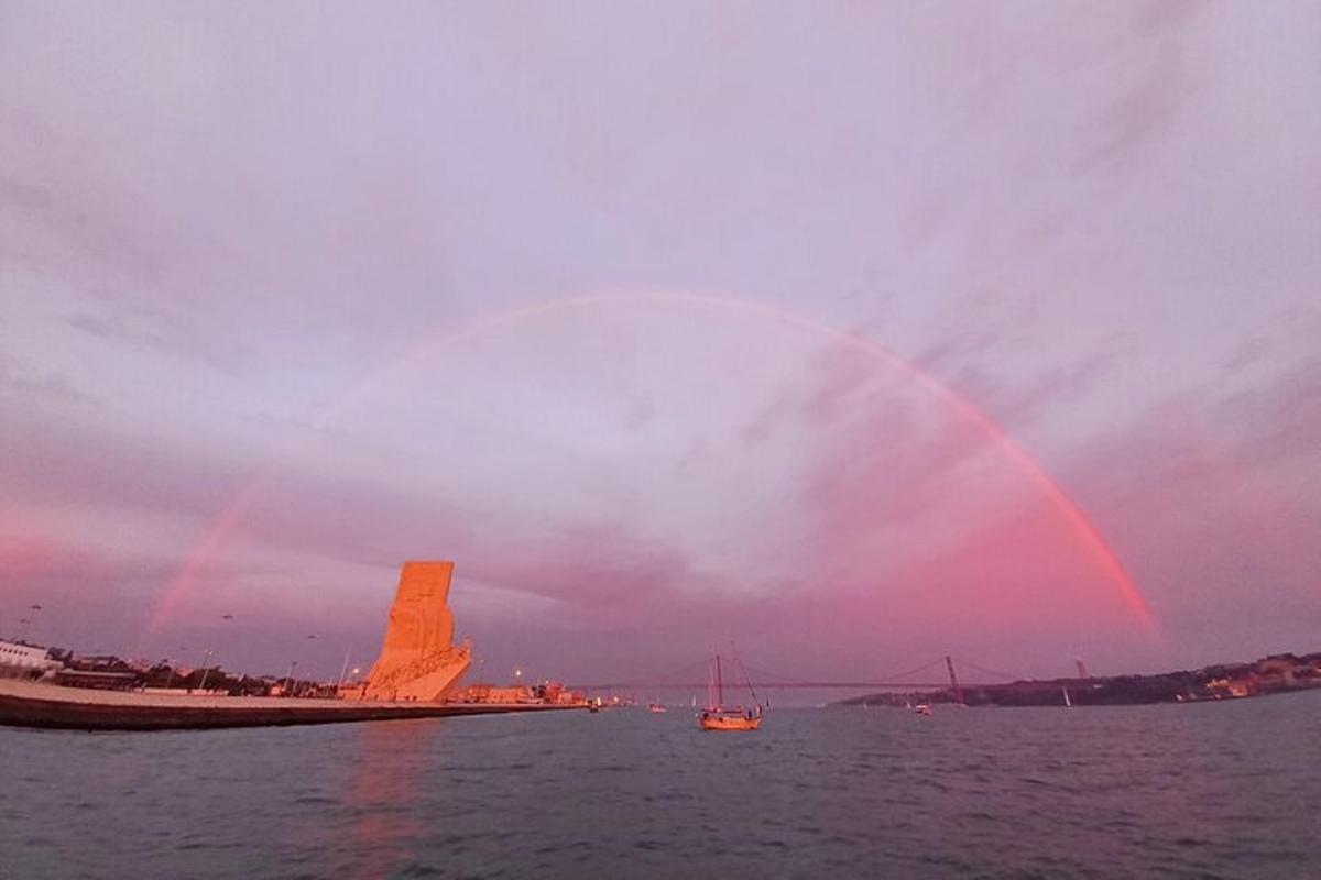 Un arcoíris en el cielo sobre el agua con un barco.