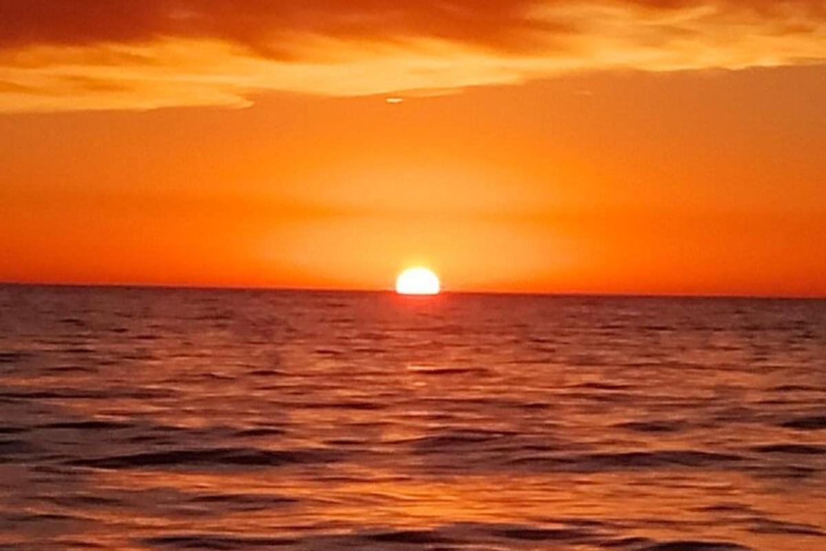 západ slunce nad oceánem se zapadajícím sluncem