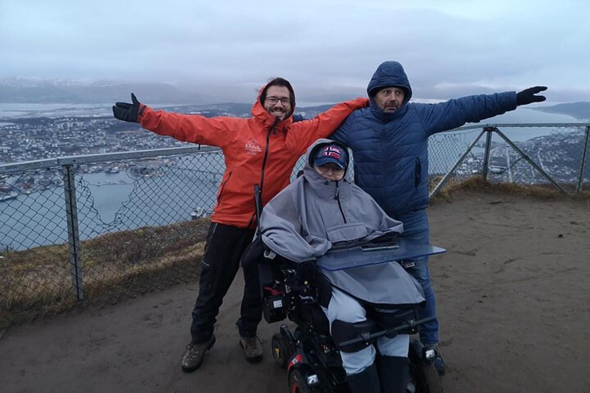a group of three people standing on top of a mountain