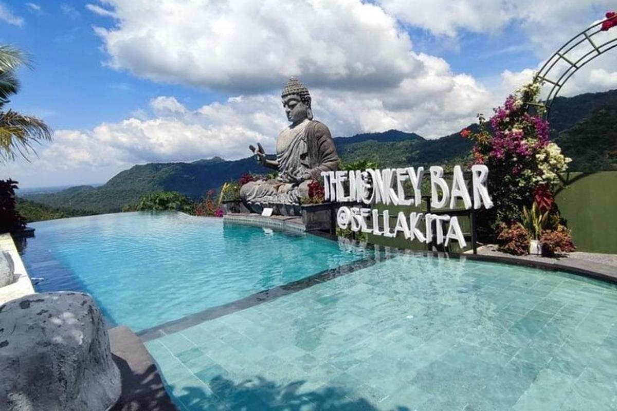 velká socha sedící vedle bazénu se sochou