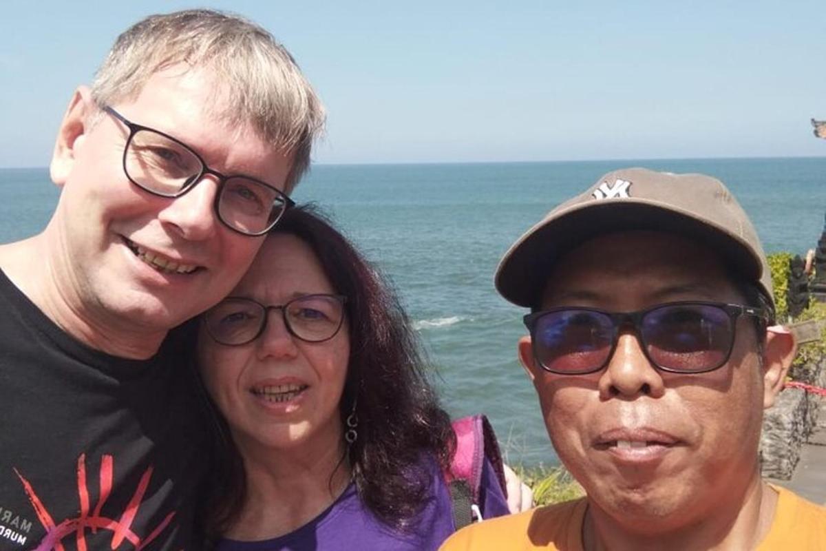 a man and a woman standing next to the ocean