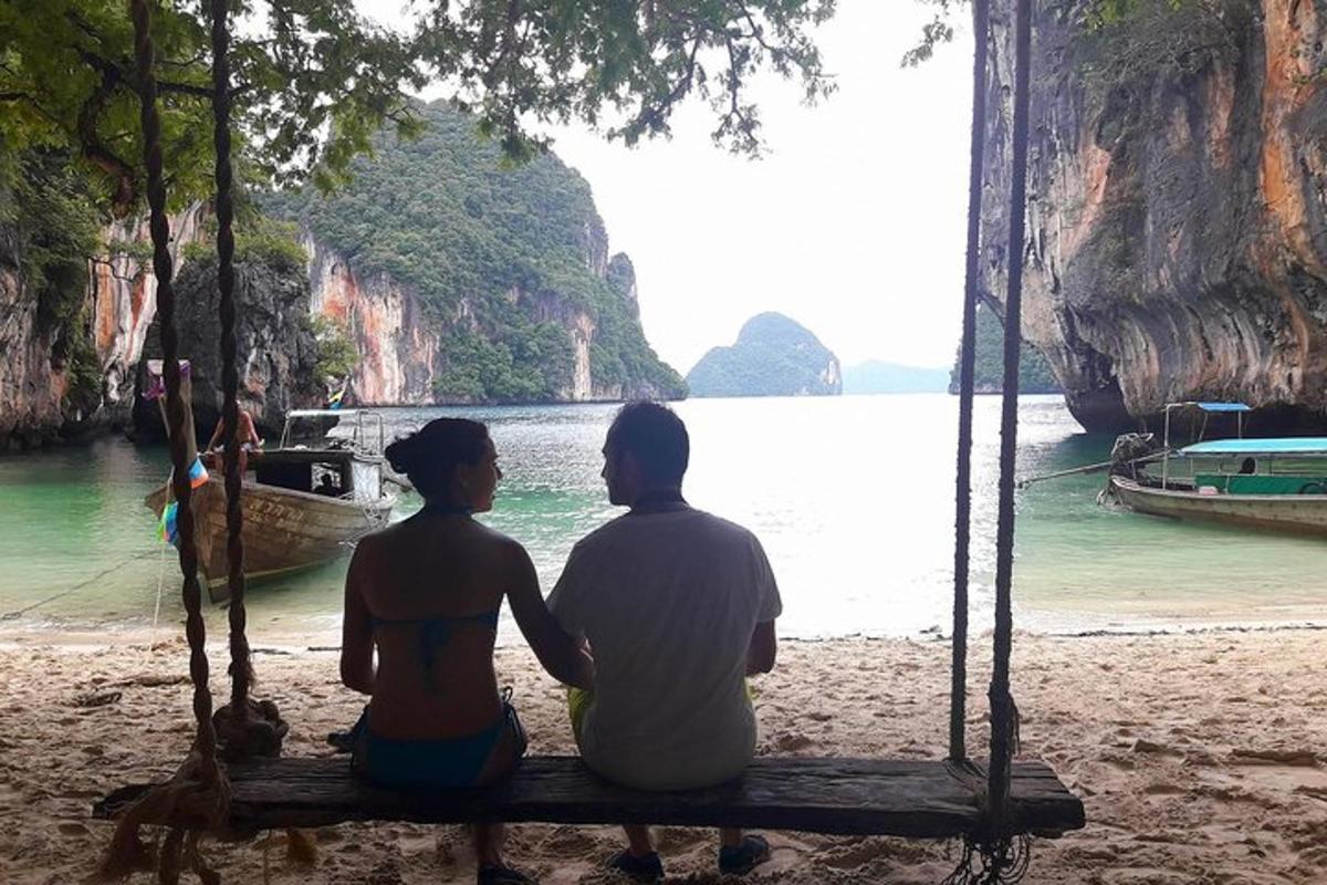 Un hombre y una mujer sentados en un columpio en una playa