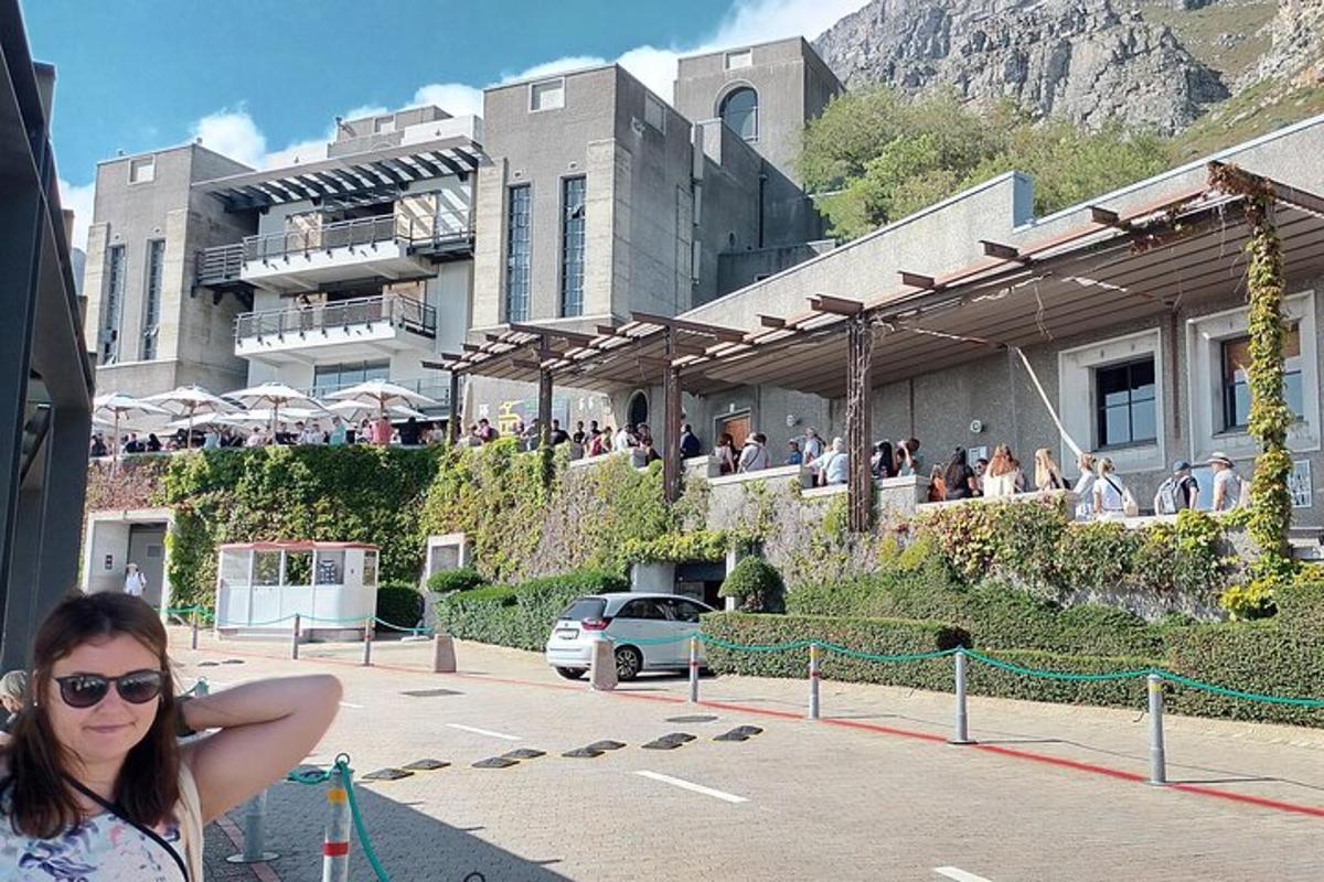 Μια γυναίκα στέκεται μπροστά από ένα κτίριο με κόσμο
